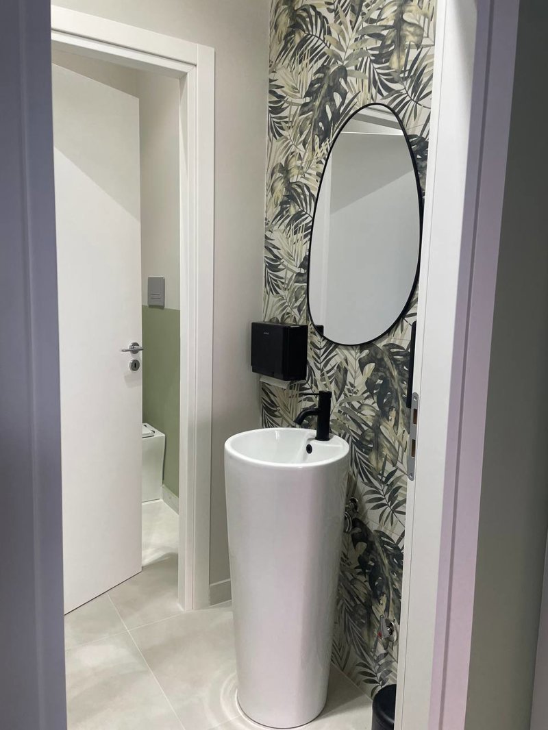 Studio Medico Reggio Calabria – Realizzato: antibagno con vista completa su lavabo freestanding, specchio ovale e rivestimento botanico Mirage Palm