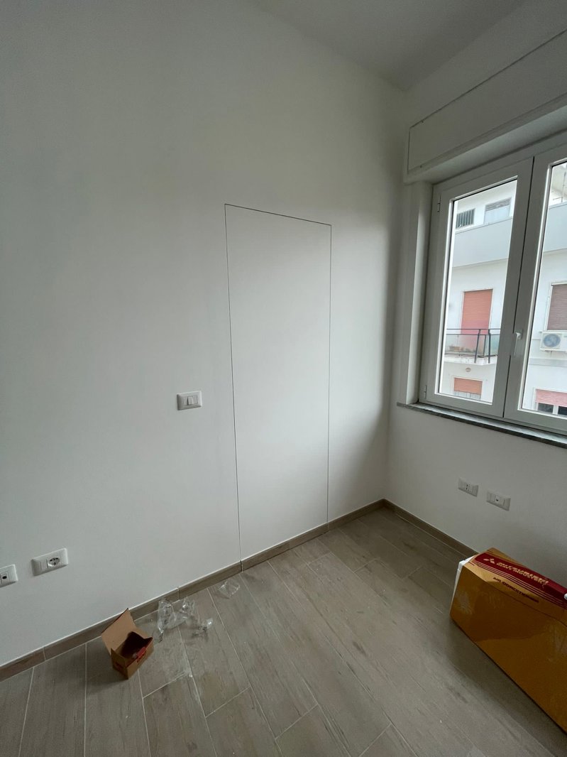 Ristrutturazione Appartamento Reggio Calabria – Cantiere camera: porta raso muro a scomparsa e pavimento effetto legno